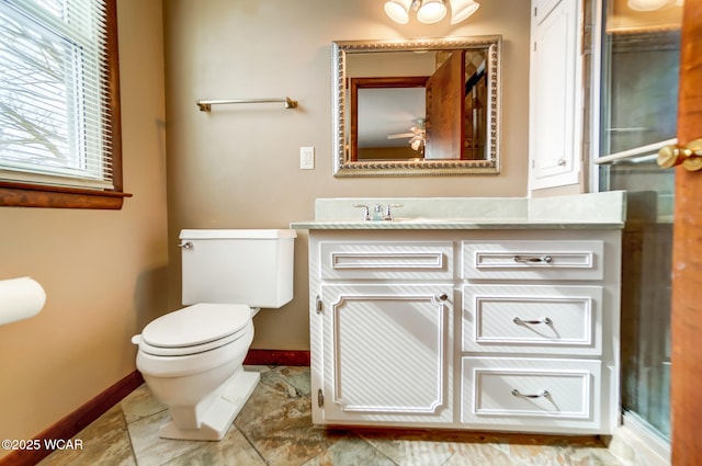 bathroom with toilet, vanity, and baseboards