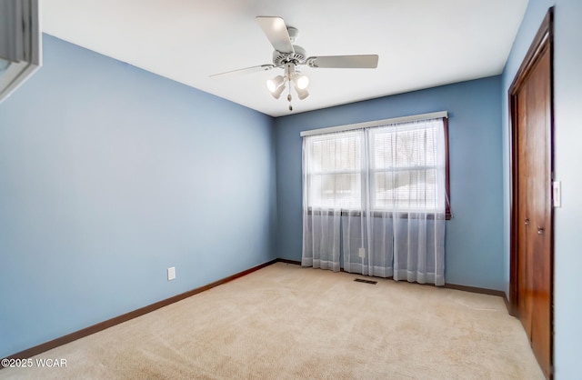 unfurnished room featuring visible vents, baseboards, a ceiling fan, and light colored carpet