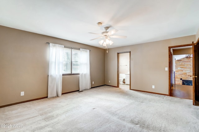 spare room with ceiling fan, light colored carpet, and baseboards