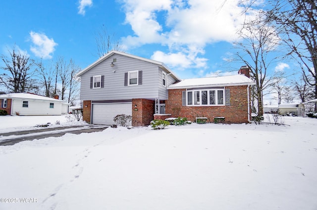 tri-level home with an attached garage, a chimney, and brick siding