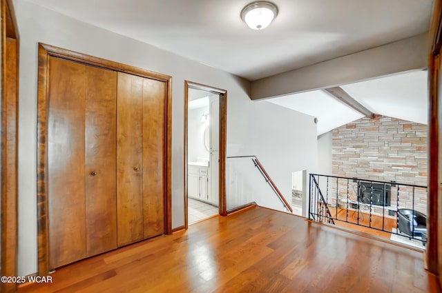 interior space with lofted ceiling with beams and light wood-type flooring