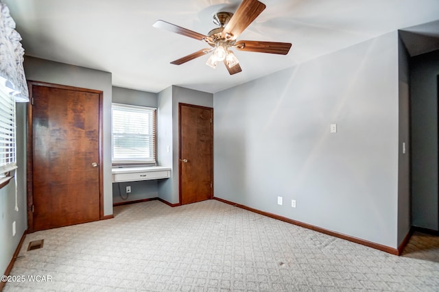 unfurnished bedroom featuring a ceiling fan, visible vents, and baseboards