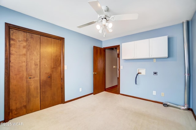 unfurnished bedroom featuring a ceiling fan, baseboards, a closet, and light colored carpet