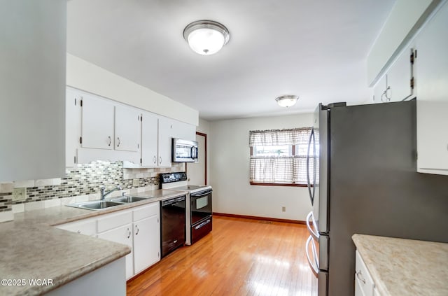 kitchen featuring white cabinetry, stainless steel appliances, a sink, and light countertops