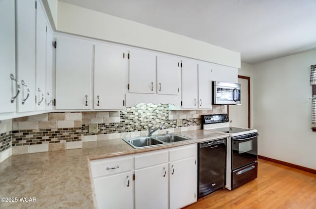 kitchen featuring black dishwasher, range with electric stovetop, light countertops, stainless steel microwave, and a sink