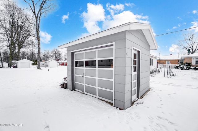 snow covered garage with a detached garage