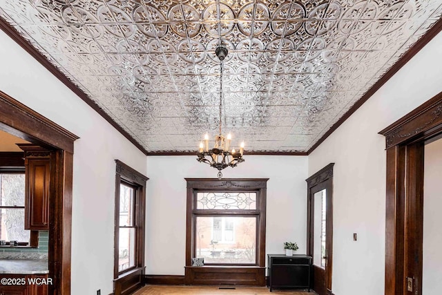 foyer featuring ornamental molding and a chandelier