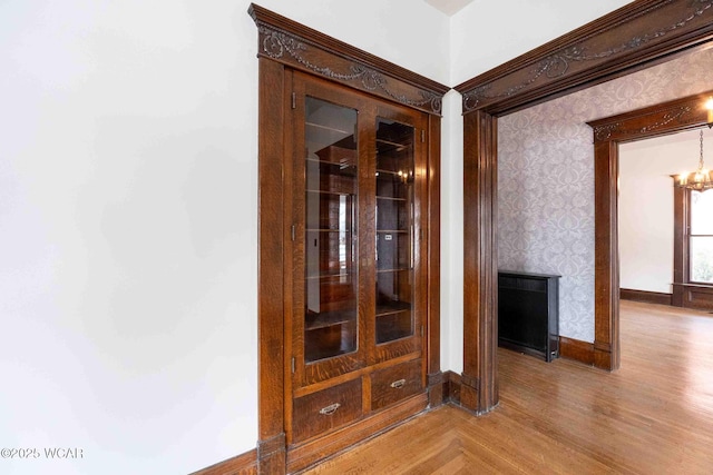 hall with wood-type flooring and a chandelier