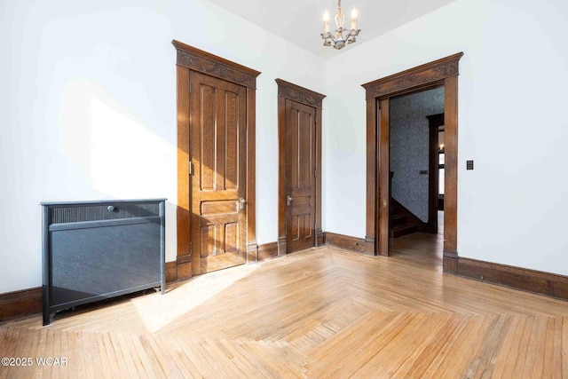 unfurnished room featuring an inviting chandelier and light parquet floors