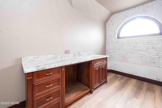 bathroom with lofted ceiling, vanity, and hardwood / wood-style flooring