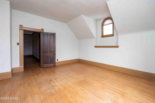 additional living space featuring lofted ceiling and wood-type flooring