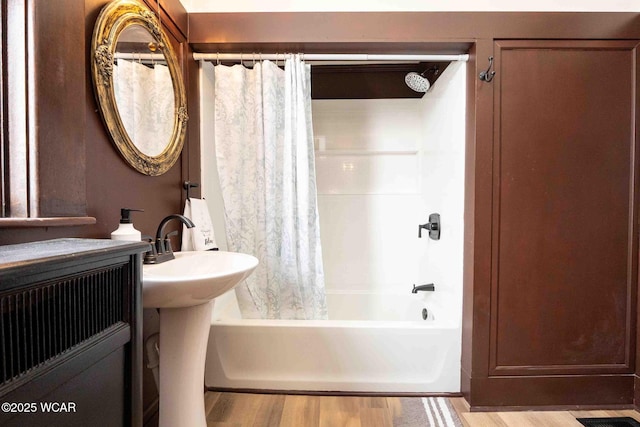 bathroom with wood-type flooring and shower / tub combo