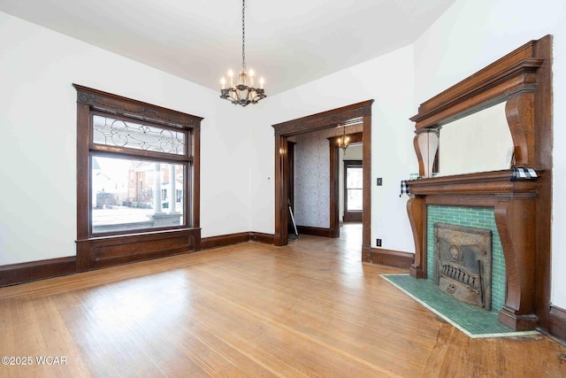 unfurnished living room featuring hardwood / wood-style flooring and a chandelier