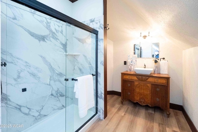 bathroom with wood-type flooring, an enclosed shower, a textured ceiling, and vanity