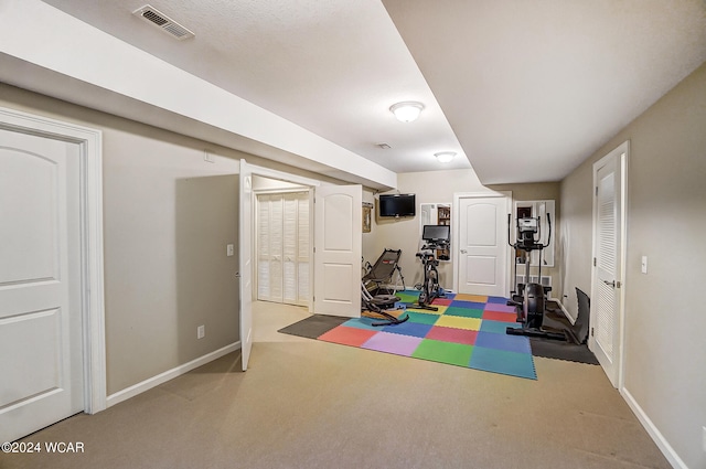 exercise room with carpet, baseboards, and visible vents