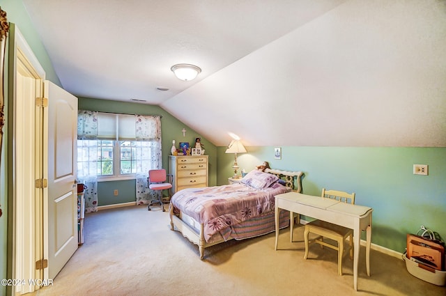 bedroom with lofted ceiling, light carpet, and baseboards