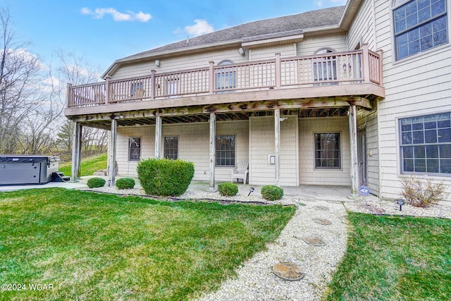 exterior space featuring a front yard, roof with shingles, and a hot tub