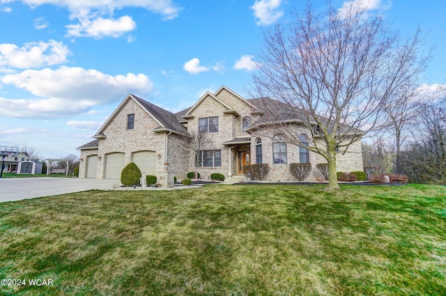 french provincial home with brick siding, a shingled roof, a garage, driveway, and a front lawn