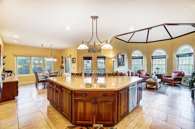 kitchen featuring hanging light fixtures, light countertops, french doors, a sink, and light tile patterned flooring