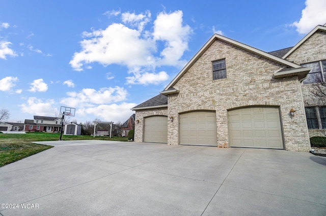 view of property exterior featuring brick siding and driveway