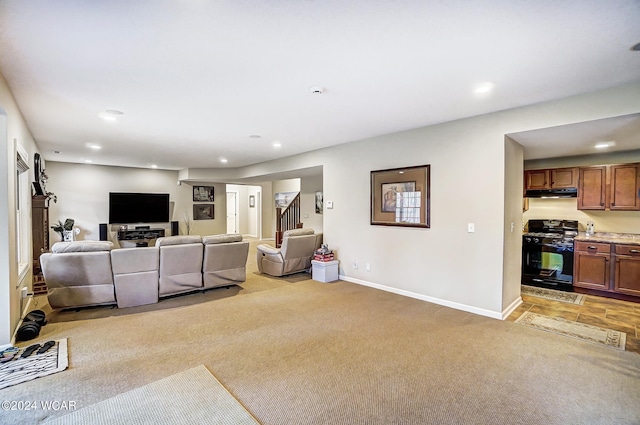 living room with recessed lighting, stairs, baseboards, and light colored carpet