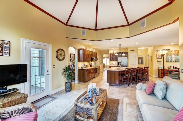 living area featuring arched walkways, visible vents, and baseboards