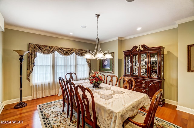 dining area featuring ornamental molding, wood finished floors, and a notable chandelier