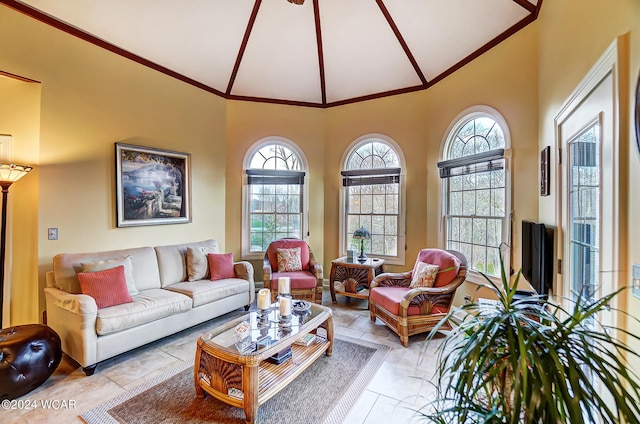 living area featuring high vaulted ceiling and ornamental molding