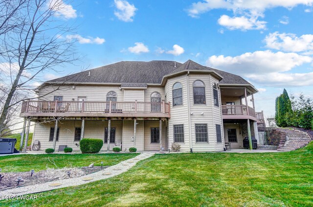 back of property with a patio area, a yard, and roof with shingles