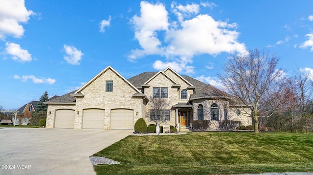 french country style house featuring an attached garage, driveway, and a front lawn