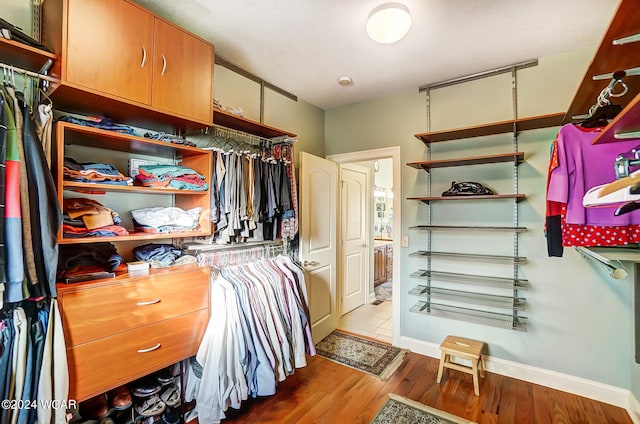 walk in closet with wood finished floors