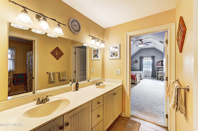 full bath featuring lofted ceiling, double vanity, a sink, and connected bathroom