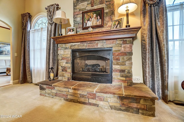 interior details featuring a fireplace and carpet flooring