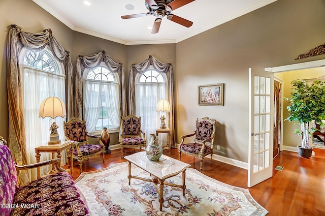 living area featuring baseboards, a ceiling fan, wood finished floors, crown molding, and french doors