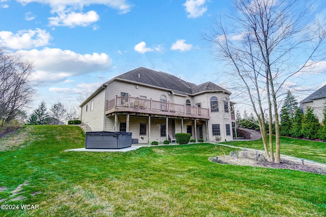 back of house with a deck, a yard, and a hot tub