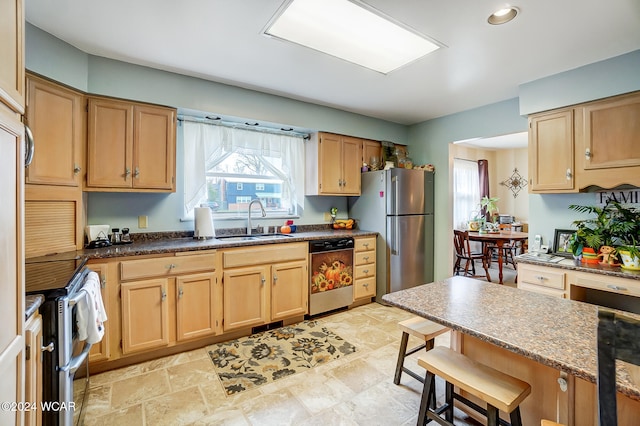 kitchen featuring dark stone countertops, sink, and appliances with stainless steel finishes