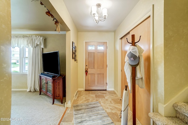 foyer entrance featuring an inviting chandelier and light carpet