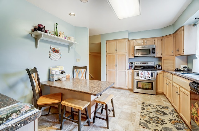 kitchen featuring stainless steel appliances, light brown cabinets, light stone counters, and a kitchen bar