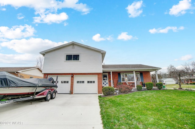 tri-level home featuring a garage, covered porch, and a front yard