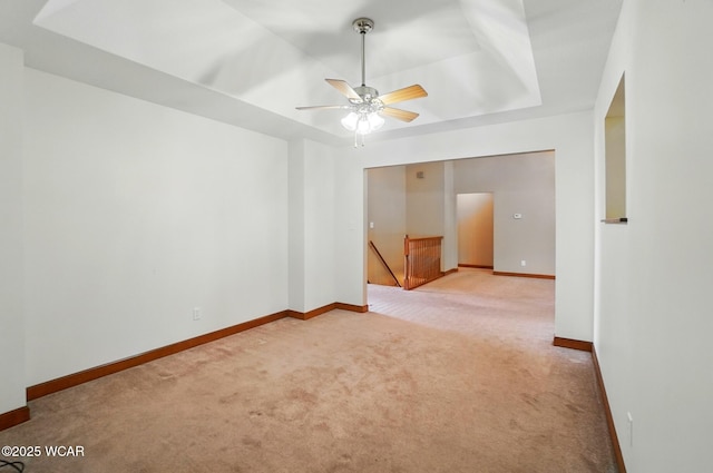 411 Ethan Cir, Bluffton, OH 45817 - unfurnished room with light carpet, baseboards, ceiling fan, and a raised ceiling