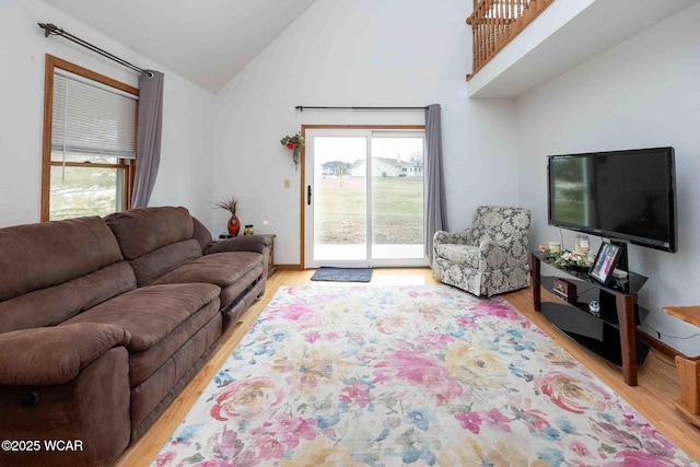 living room with lofted ceiling, plenty of natural light, and light wood-type flooring