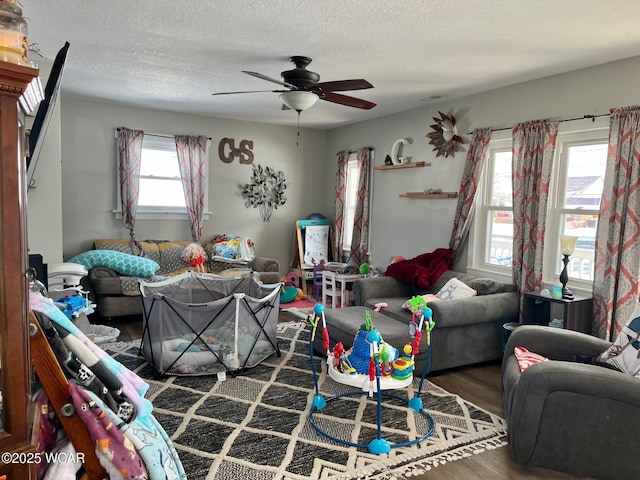 living area featuring a textured ceiling, visible vents, wood finished floors, and a ceiling fan