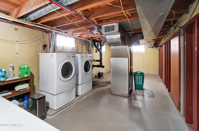 laundry room with heating unit and washer and dryer