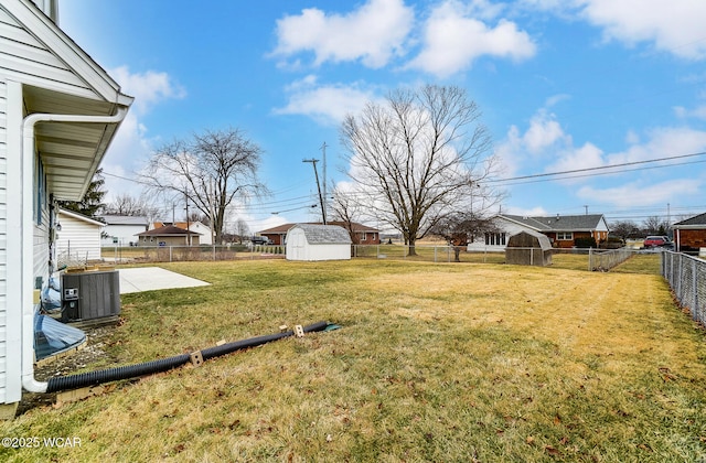 view of yard with a shed, central air condition unit, and a patio area