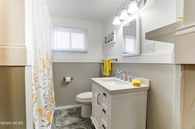 bathroom featuring a healthy amount of sunlight, toilet, and vanity