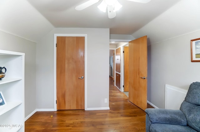 sitting room with ceiling fan, lofted ceiling, and wood-type flooring