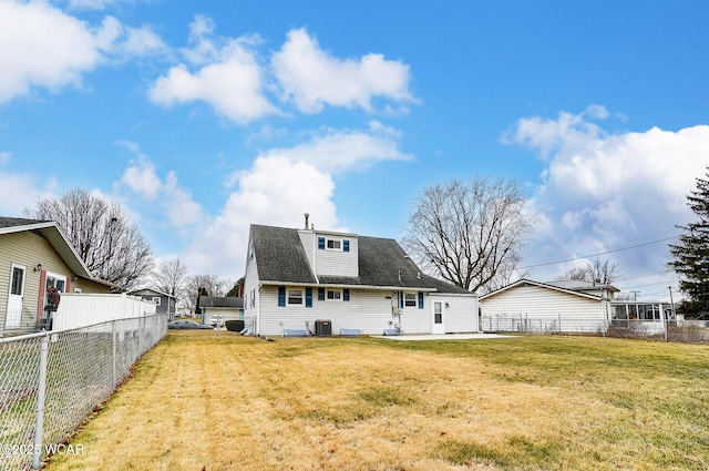 rear view of house featuring central AC unit and a lawn