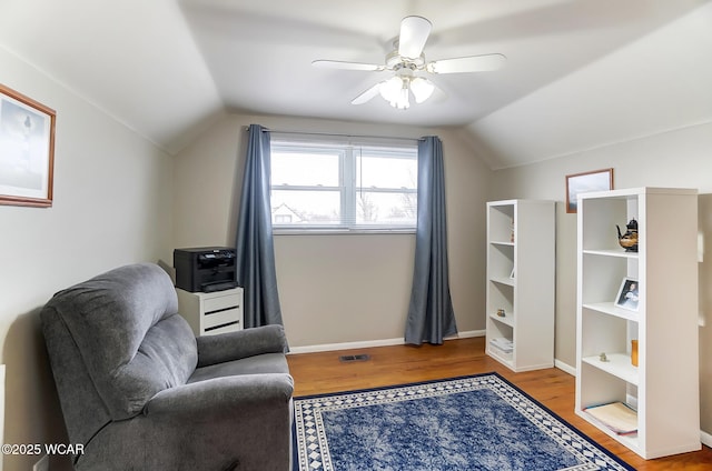 living area with vaulted ceiling, ceiling fan, and light wood-type flooring