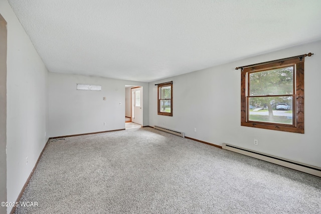 514 S Wayne St, Van Wert, OH 45891 - spare room featuring a baseboard heating unit, carpet floors, baseboards, and a textured ceiling