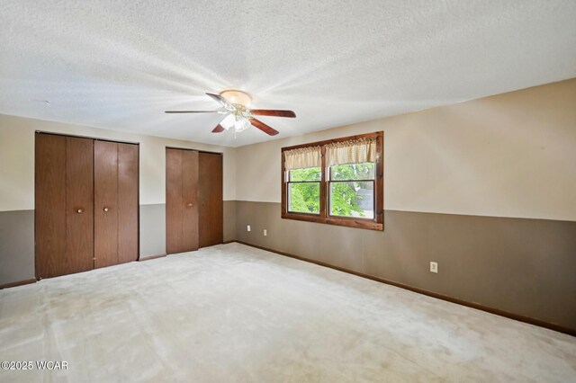 514 S Wayne St, Van Wert, OH 45891 - unfurnished bedroom featuring two closets, carpet flooring, ceiling fan, baseboards, and a textured ceiling